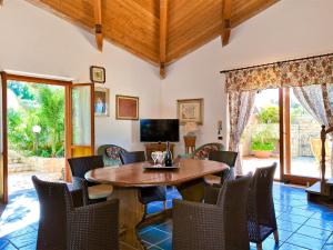 Una sala de estar con una mesa y sillas de madera. en Villa Le Palme by Interhome, en Valderice