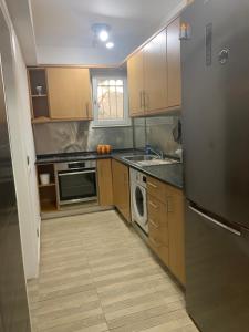 a small kitchen with a refrigerator and a dishwasher at Dori's Seaside Apartment in Athens