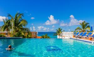a woman in a swimming pool overlooking the ocean at La Vista Resort in Simpson Bay