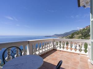 een balkon met een tafel en uitzicht op de oceaan bij Villa Villa incredible View by Interhome in Mortola Superiore