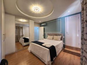 a bedroom with a large bed and a large mirror at Pousada Behling Haus in Pomerode