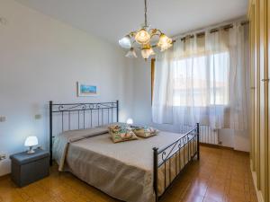 a bedroom with a bed and a chandelier at Apartment Casa di Neva by Interhome in Marina di Cecina