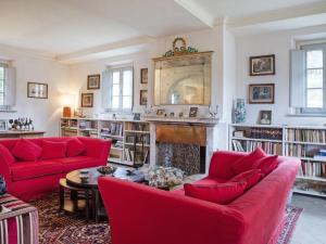 a living room with red couches and a fireplace at Villa Ghizzano by Interhome in Peccioli