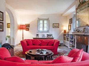PeccioliにあるVilla Ghizzano by Interhomeの赤いソファとテーブルのあるリビングルーム