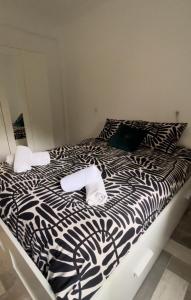 een zwart-wit bed met handdoeken erop bij Lovely Rooms en piso compartido in Sevilla