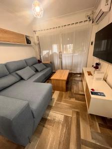 een woonkamer met een blauwe bank en een tafel bij Lovely Rooms en piso compartido in Sevilla