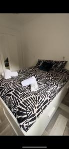 een zwart-wit bed met 2 handdoeken erop bij Lovely Rooms en piso compartido in Sevilla