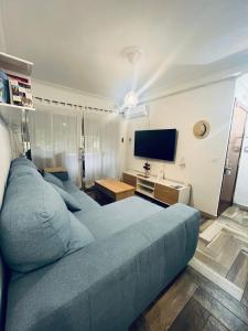 een slaapkamer met een blauw bed en een flatscreen-tv bij Lovely Rooms en piso compartido in Sevilla +2 foto's