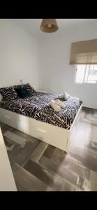 een bed in een kamer met een zebraprint-deken bij Lovely Rooms en piso compartido in Sevilla