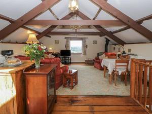ein Wohnzimmer mit Tisch und Wohnzimmer in der Unterkunft Beckaford Cottage in Newton Abbot