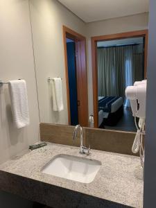 a bathroom with a sink and a mirror at Quinta Santa Barbara Cota Resort in Pirenópolis