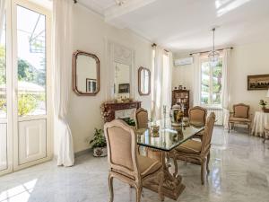 een eetkamer met een glazen tafel en stoelen bij Villa Villa incredible View by Interhome in Mortola Superiore