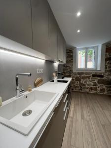 una cucina con lavandino bianco e muro di mattoni di "Calm Joy & J" - Lithops a Ermoupoli