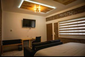 a bedroom with a bed and a desk and a tv at TARAMURI HOTEL & TOURS in Creel