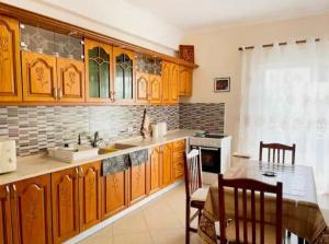 une cuisine avec des placards en bois et une table ainsi qu'une salle à manger dans l'établissement Comfortable apartment, à Tirana 4 autres photos