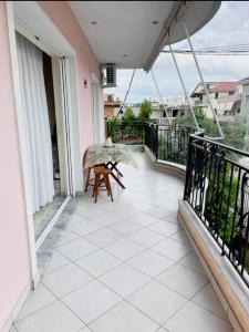 - un balcon avec une table et un parasol dans l'établissement Comfortable apartment, à Tirana