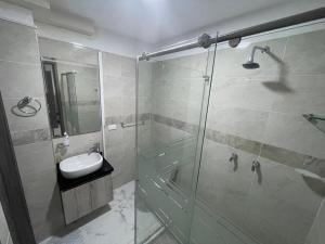 a bathroom with a glass shower and a sink at La Roca 101 in Cali