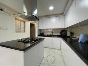 a kitchen with white cabinets and a black counter top at La Roca 101 in Cali +17 photos