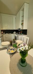 a kitchen with a table with a vase of flowers on it at Cozy studio apartment in the center of Rovaniemi in Rovaniemi