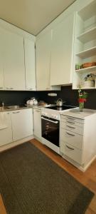 a kitchen with white cabinets and a stove top oven at Cozy studio apartment in the center of Rovaniemi in Rovaniemi +12 photos
