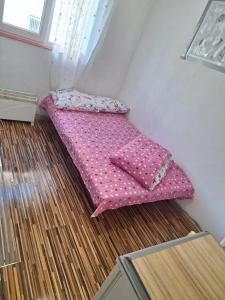 ティミショアラにあるone roomのピンクベッド1台(床に座った部屋内)