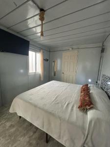a large white bed in a bedroom with a ceiling at Casa Terra cerca de Playa in Barra de Navidad