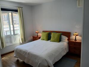 Un dormitorio con una cama con almohadas verdes y una ventana. en Sounds of The Sea Apartment, en Playa Blanca