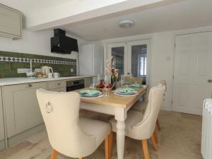 une cuisine avec une table et des chaises en bois dans l'établissement Belvedere Cottage, à Weymouth