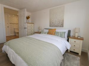 une chambre avec un grand lit blanc et une salle de bain dans l'établissement Belvedere Cottage, à Weymouth