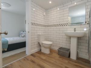 une salle de bain avec toilettes et lavabo et un lit dans l'établissement Belvedere Cottage, à Weymouth 35 autres photos