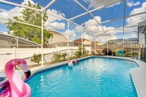 a swimming pool with a pink flamingo in the water at Disney-Themed Villa with Heated Pool, 10 Mi to Parks in Kissimmee