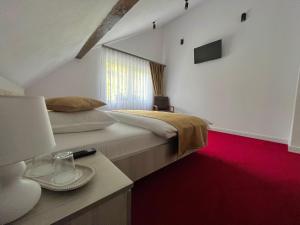 a bedroom with a large bed and a red carpet at Casa Bobu Arieseni in Arieşeni +30 photos