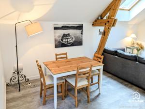 a dining room with a table and chairs and a couch at Les Charmes - Climatisation - Terrasse - Nature in Boigny-sur Bionne +6 photos
