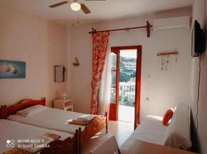 a bedroom with two beds and a sliding glass door at Kandilari Apartments in Kókkinon Nerón