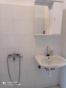 a white bathroom with a sink and a shower at Kandilari Apartments in Kókkinon Nerón