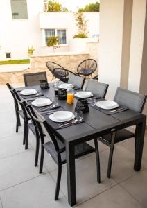 a black table with chairs and plates and orange juice at Villa Blue Horizon in Seget Donji