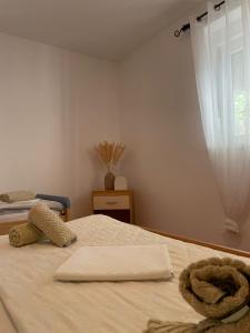 a bedroom with a bed with white sheets and a window at APP Mirela 3 in Novi Vinodolski