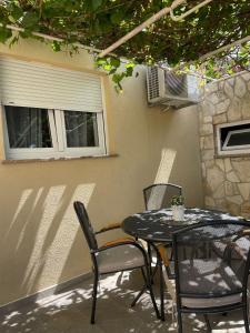 a black table and chairs on a patio at APP Mirela 3 in Novi Vinodolski +10 photos