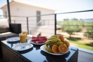 a table with two plates of fruit on top of it at Three Charites Resort in Gialova