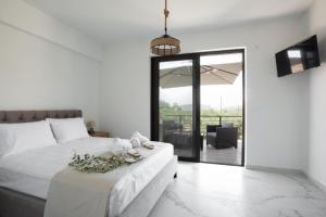 a bedroom with a white bed with flowers on it at Three Charites Resort in Gialova +61 photos