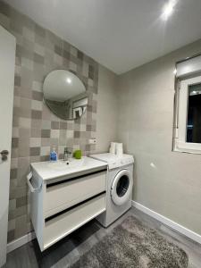 Un baño con lavadora y lavabo. en Casa Vacacional en Louro, en Muros