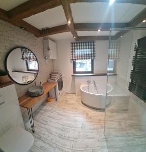 a bathroom with a tub and a sink and a mirror at Malinowa Chata- Królowy Most in Królowy Most +10 photos