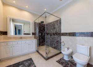 Un baño con ducha, inodoro y lavabo. en Villa Rossini, en Marbella
