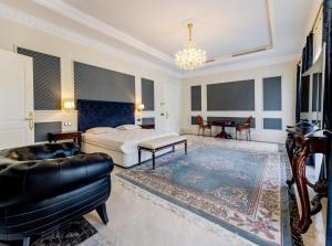 Un dormitorio con una cama, un sofá y una mesa. en Villa Rossini, en Marbella