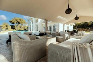 un patio al aire libre con sofás y sillas y una piscina en Villa Rossini, en Marbella
