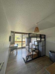 a room with a bunk bed and a desk in a room at Appartement au pied des pistes in Le Corbier