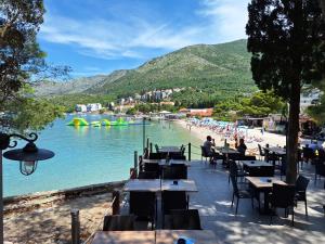a beach with tables and chairs next to a body of water at Sea Star Apartment in Cavtat