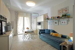 un soggiorno con un divano blu e una cucina di Casa Lux ampio monolocale ad Alassio