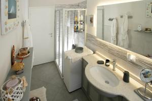 un bagno con lavandino e specchio di Casa Lux ampio monolocale ad Alassio
