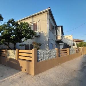a house with a fence in front of it at Makri Vacation House in Alexandroupoli